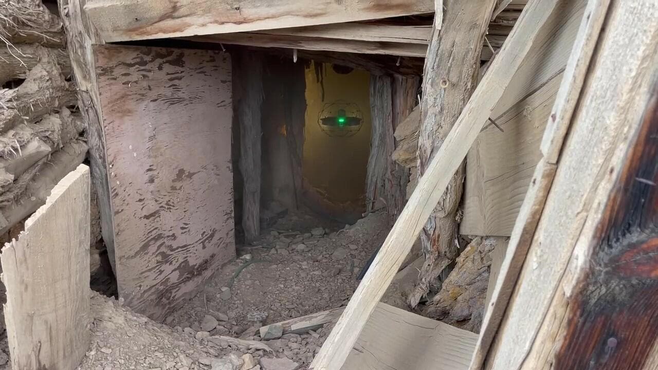 Ground-level view looking into mine tunnel with aerial drone deployed within tunnel.